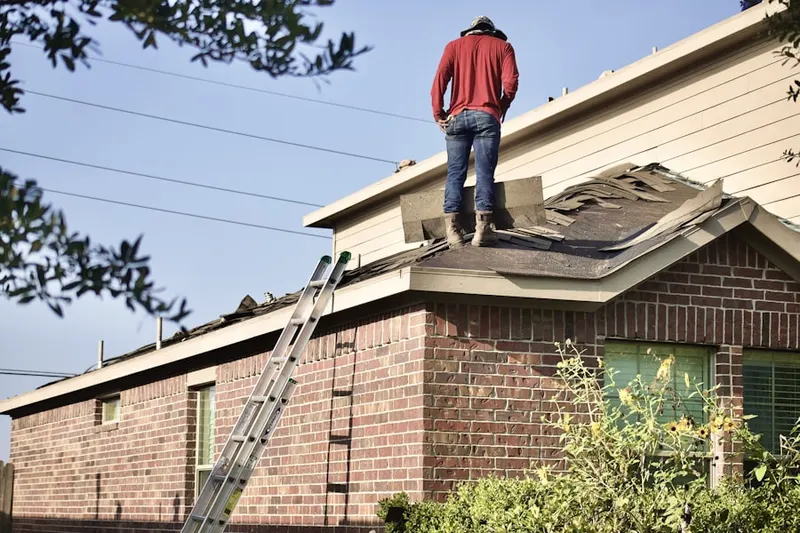 Professional roofer working on a residential roof in Fort Morgan